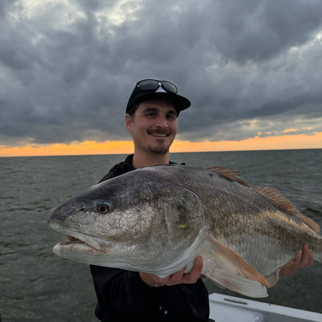 Angler holds up a monster 47 inch red drum.