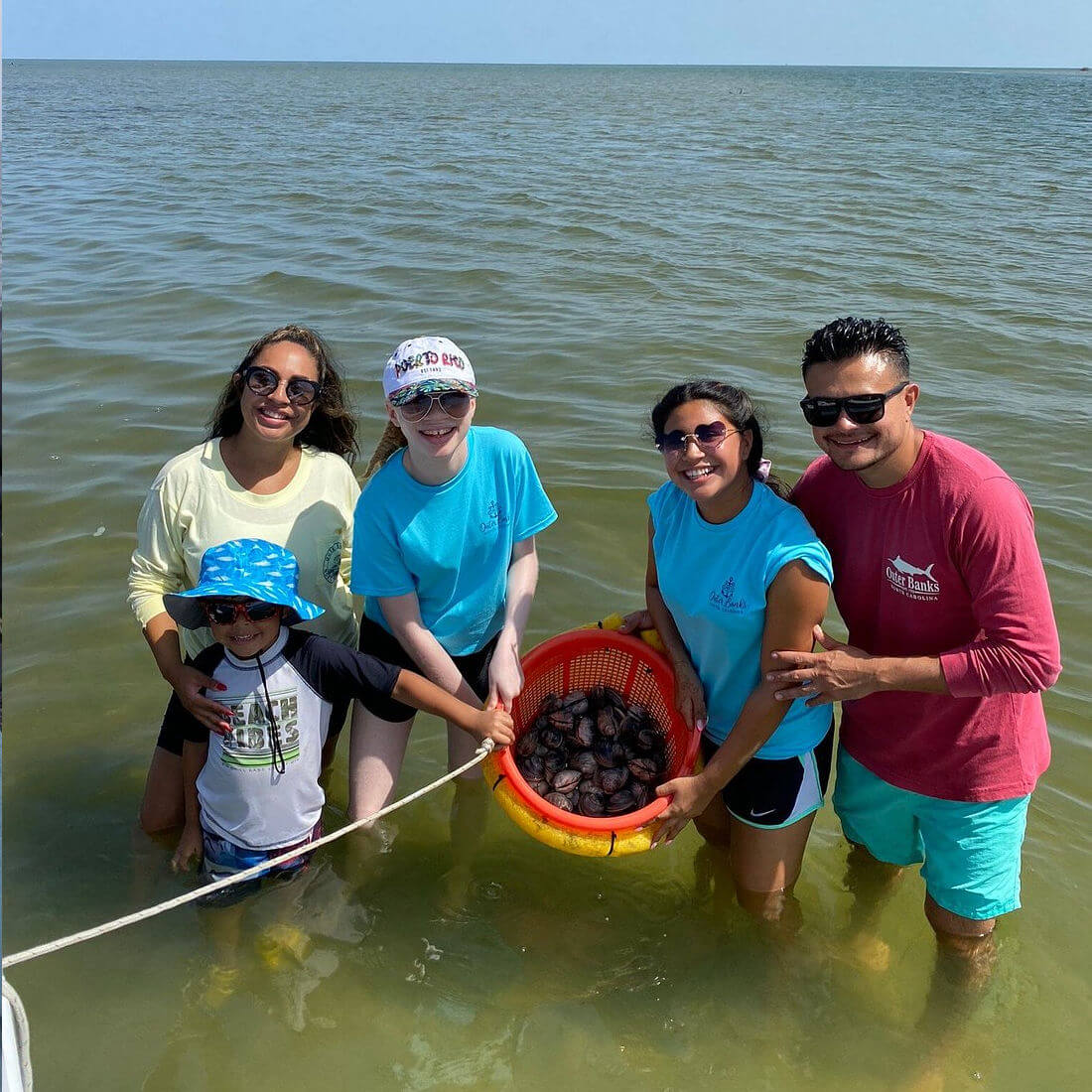 Family shows off their harvest of clams.
