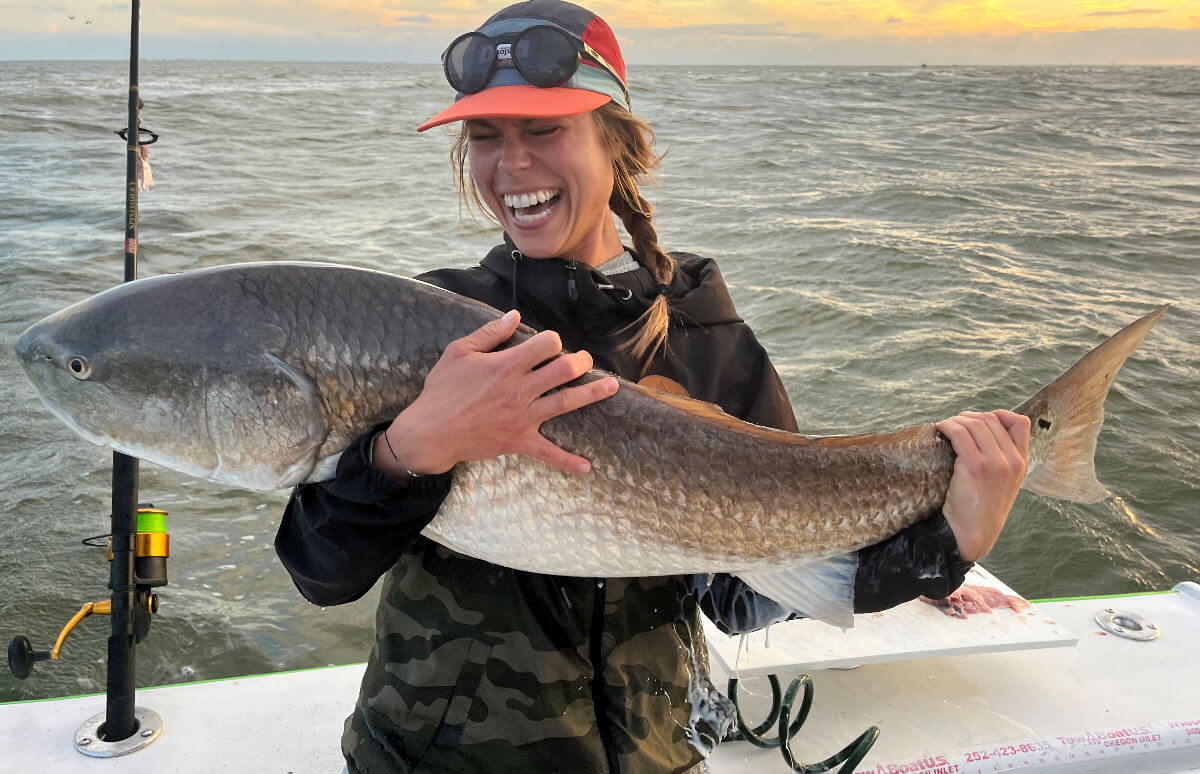 Pretty lady shows off a monster trophy red drum.